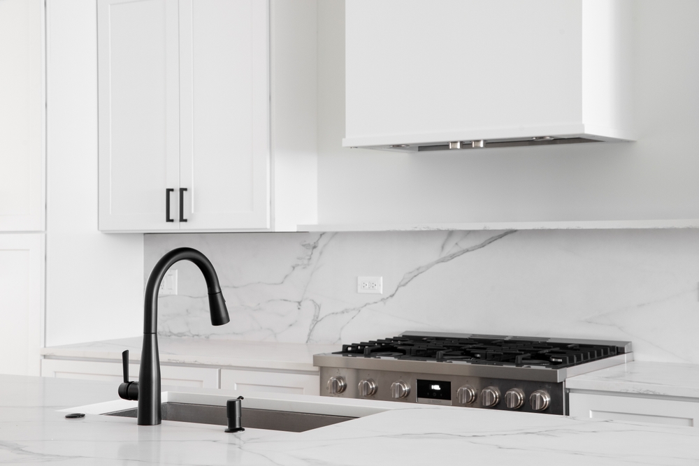 An,All,White,Kitchen,With,A,Black,Faucet,On,A