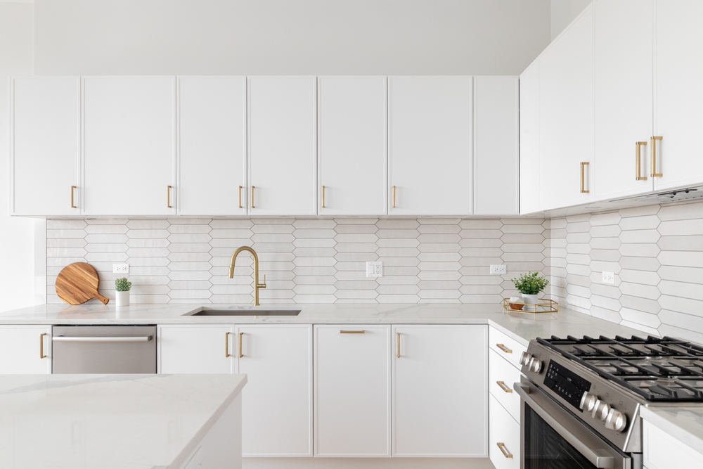 A,Beautiful,Kitchen,Detail,With,White,Cabinets,,A,Gold,Faucet,